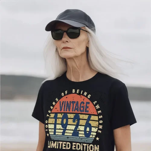 Older woman wearing a black ladies T shirt with “100 Years of Being Awesome” vintage birthday design, celebrating a 100th birthday milestone.