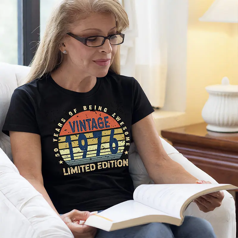 Middle-aged woman wearing a black ladies 50th birthday T shirt with “50 Years of Being Awesome” design