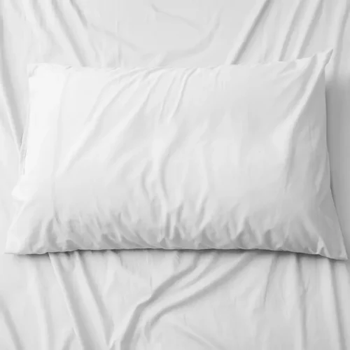 Cotton Pillow Case in White, front view on white sheets