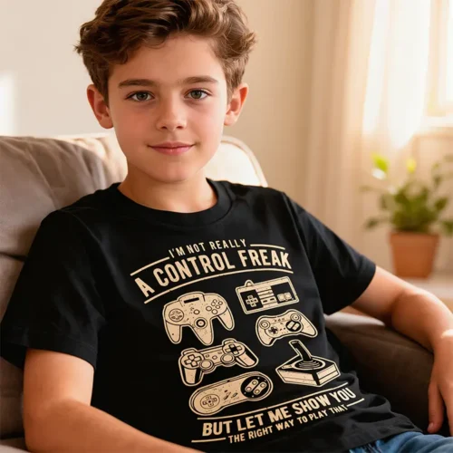 Teenage boy wearing the Control Freak kids gaming t-shirt in black while sitting on a couch in a lounge room