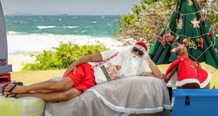 Santa relaxing at an Australian beach wearing a custom Christmas t shirt