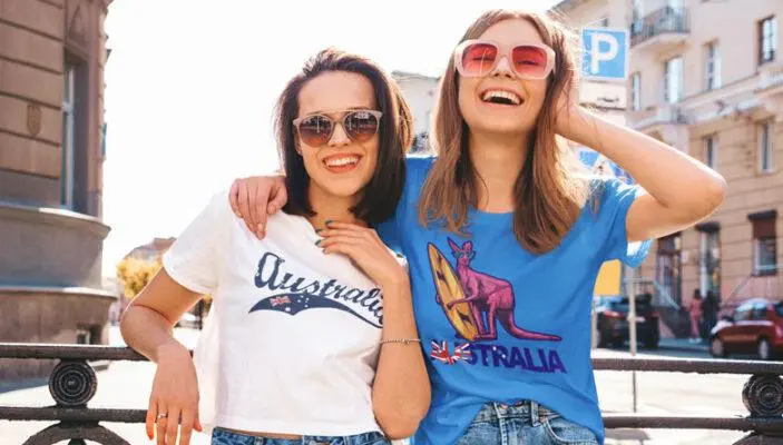 Two women wearing custom printed crop tops with Australian themed designs