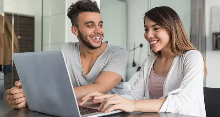 Two people using a laptop to plan a custom T shirt design with free design apps, AI art and print-ready artwork tools.