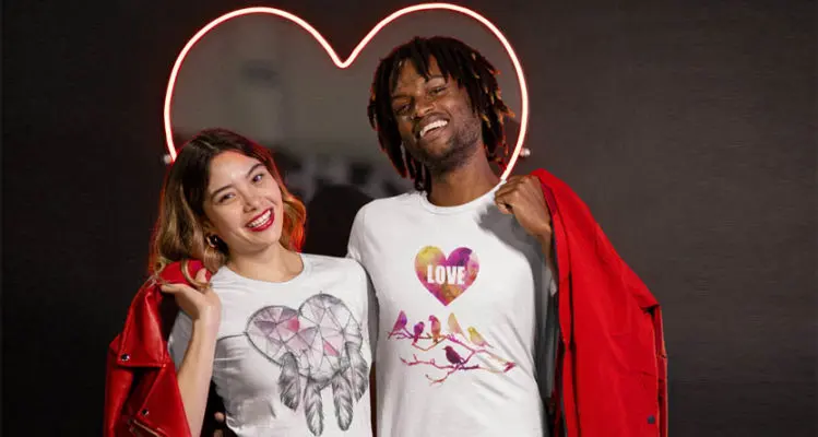 Couple wearing custom Valentine’s Day T shirts with a heart light behind them