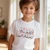 Boy wearing the Happy Birthday kids t-shirt in white while standing in a park
