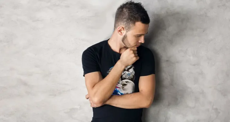 Man wearing a custom printed black t-shirt while reviewing the design and ordering process