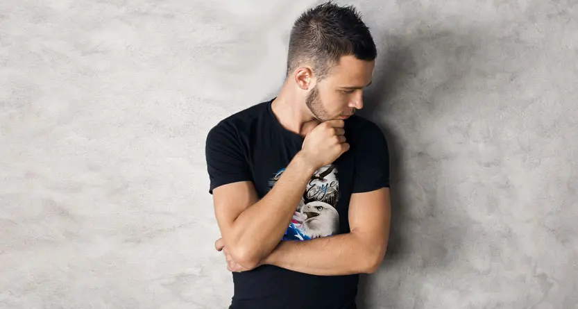 Man wearing a custom printed black t-shirt while reviewing the design and ordering process