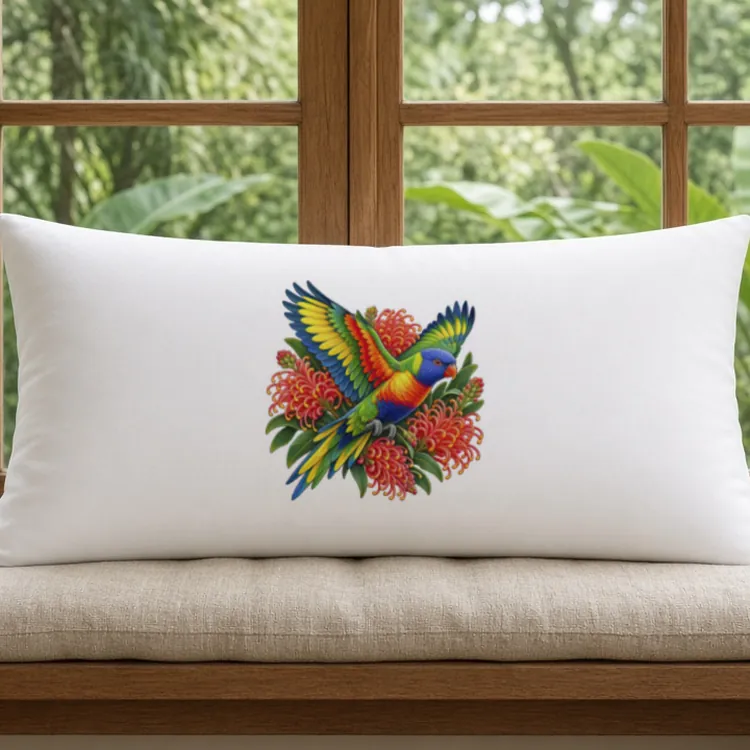 White Rainbow Lorikeet with Grevillea pillow case on a cushioned window seat, with a timber-framed window and garden greenery behind