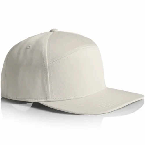 Angled side view of the Bone AS Colour Stock 7-Panel Cap 1184 showing the crown shape, stitched eyelet and flat peak